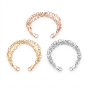 May include: Three multi-strand chain bracelets featuring a lobster claw clasp at each end. The set includes one rose gold-toned bracelet, one gold-toned bracelet, and one silver-toned bracelet, each constructed from multiple delicate interlocking metal links.
