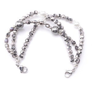 May include: A silver bracelet with two large gray beads and smaller silver beads. The bracelet has two silver clasps.