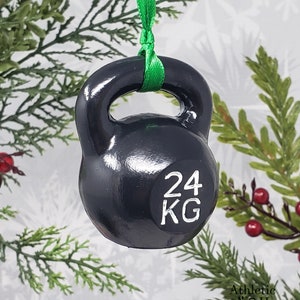 May include: Black kettlebell Christmas ornament with a green ribbon and the text "24 KG" on the side.