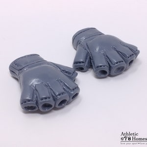 Puede incluir: Un par de guantes sin dedos grises con un dise&ntilde;o cosido. Los guantes est&aacute;n hechos de un material suave y flexible.