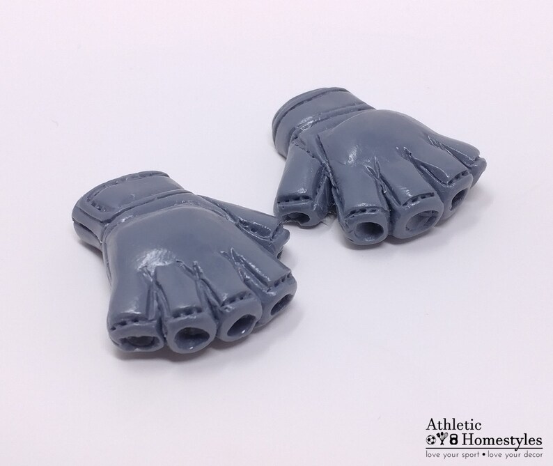 Puede incluir: Un par de guantes sin dedos grises con un dise&ntilde;o cosido. Los guantes est&aacute;n hechos de un material suave y flexible.