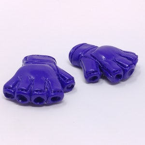 Puede incluir: Dos guantes sin dedos de color morado con una superficie texturizada. Los guantes est&aacute;n hechos de un material suave y flexible.