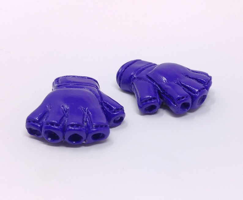 Puede incluir: Dos guantes sin dedos de color morado con una superficie texturizada. Los guantes est&aacute;n hechos de un material suave y flexible.