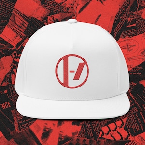 Könnte beinhalten: Eine weiße Flat-Bill-Baseballkappe mit einem roten kreisförmigen Logo, das ein stilisiertes "-7-"-Design zeigt. Die Kappe hat eine grüne Unterseite und eine strukturierte Passform.
