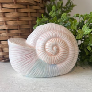 May include: A set of three ceramic mugs with a speckled, matte finish. The mugs are in shades of cream, light gray, and dark gray. Each mug has a simple, minimalist design, perfect for coffee or tea.