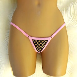 May include: Pink thong underwear with a black mesh center panel. The lingerie has thin straps and a minimalist design. The garment is displayed on a mannequin.