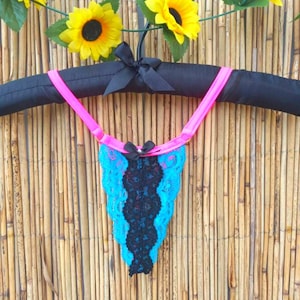Peut inclure: Lingerie en dentelle bleue et noire avec des liens en ruban rose suspendus à un cintre noir.