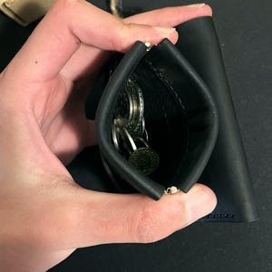 Münzfach mit Federbügel, mit einer Hand geöffnet
