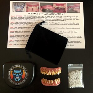 Op de afbeelding: Een set vampierstanden in een zwarte doos met een zakje witte korrels en instructies over hoe ze te passen. De instructies bevatten de tekst "FX Fangs Fitting Instructions".