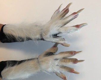 May include: A pair of white furry werewolf gloves with long claws. The gloves are made of a soft, realistic-looking fur and have detailed claws.