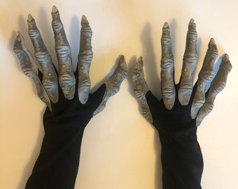 May include: A pair of black gloves with grey, clawed hands attached. The gloves are long and extend past the wrist.