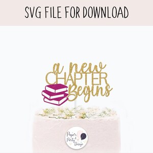 Peut inclure: Un cake topper avec le texte "a new chapter begins" en script doré à paillettes, avec une pile de trois livres magenta. Les mots "SVG FILE FOR DOWNLOAD" sont en haut. Le gâteau est blanc avec des décorations florales.