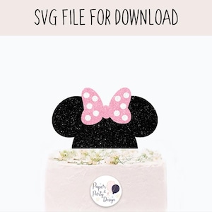 May include: Black and pink glitter mouse ears with a pink bow and white polka dots. The ears are on top of a white cake with pink frosting.