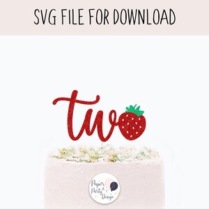 May include: A red glittery "two" cake topper with a strawberry design. The strawberry has green leaves. The cake topper is on top of a white cake with flowers. The text "SVG FILE FOR DOWNLOAD" is at the top.