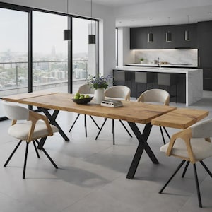 May include: A rectangular wooden dining table with a natural grain finish and black metal X-shaped legs, accompanied by four light-coloured upholstered chairs with wooden frames, positioned in a room with a kitchen island and large windows.