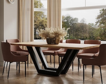 May include: A modern dining table with a wooden top and black metal legs in a V-shape. The table is surrounded by six chairs with brown upholstery.
