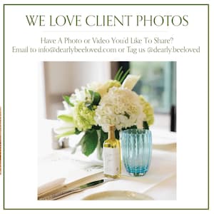 May include: A table setting featuring a floral arrangement of white and green flowers, a small bottle of olive oil, and a blue glass. The text "WE LOVE CLIENT PHOTOS" is at the top of the image.