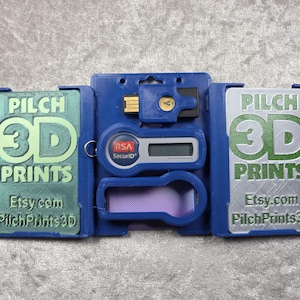 May include: A blue 3D-printed case with the text "PILCH 3D PRINTS" and "Etsy.com PilchPrints3D". The case holds a USB drive, a security token, and a purple-tinted card. The case is open, revealing the contents.
