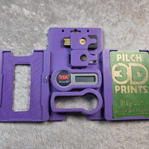 May include: A purple 3D-printed security device kit. The kit includes a card holder, a USB drive, a key fob, and an RSA SecurID device. The green card has the text "PILCH 3D PRINTS" and "Etsy.com PilotPrints3D".