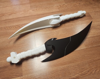 May include: Two curved blade props, one entirely white and one with a black blade and white handle. Each weapon features a pointed, crescent-shaped blade and a textured, wrapped-style grip with a pommel at the end, designed for display or cosplay.