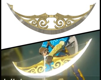 May include: A golden crescent-shaped bow with intricate details and a white string. The bow is held by a person wearing blue clothing.