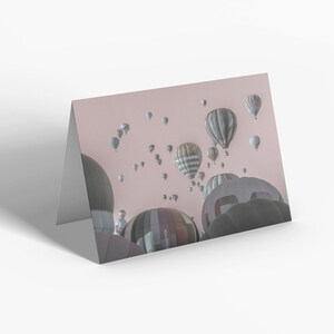 a card with hot air balloons floating in the sky