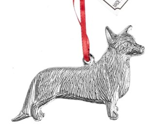 May include: A silver pewter ornament of a Welsh Corgi dog. The ornament is hanging from a red ribbon and has a tag that reads "House of  M Pewter Made in North Carolina since 1980."