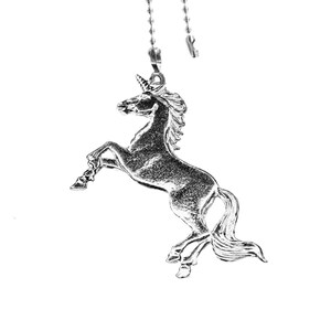 May include: A silver unicorn figurine hanging from a silver chain. The unicorn is standing on its hind legs with its head held high.