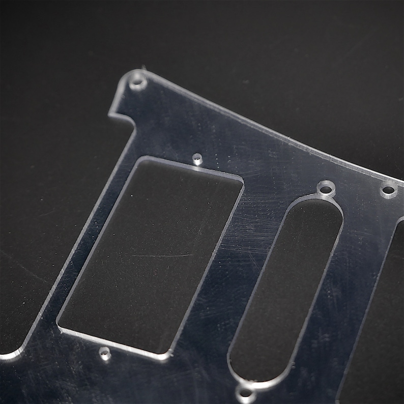 May include: A clear plastic guitar pickguard with cutouts for pickups and controls. The pickguard is designed for an electric guitar.