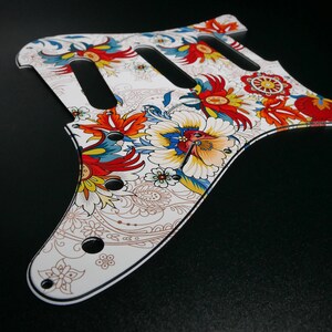 Peut inclure: Plaque de protection de guitare blanche avec un motif floral en rouge, bleu, jaune et marron. La plaque de protection a un motif cachemire et est en plastique.
