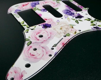 May include: White guitar pickguard with a floral pattern featuring pink and purple roses and green leaves.