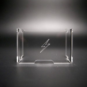 Könnte beinhalten: Ein transparenter Handyständer aus Kunststoff mit einem Blitz-Design.