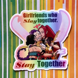 May include: A sticker with the text "Girlfriends who Slay together. Stay Together" over an illustration of three women embracing. The sticker has a rainbow gradient background and a white border.