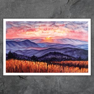 Peut inclure: Une peinture à l'aquarelle d'un coucher de soleil sur une chaîne de montagnes. Le ciel est d'un rose et d'un orange vifs, avec des nuages qui reflètent la lumière. Les montagnes sont d'un violet profond, avec un champ d'herbe dorée au premier plan.
