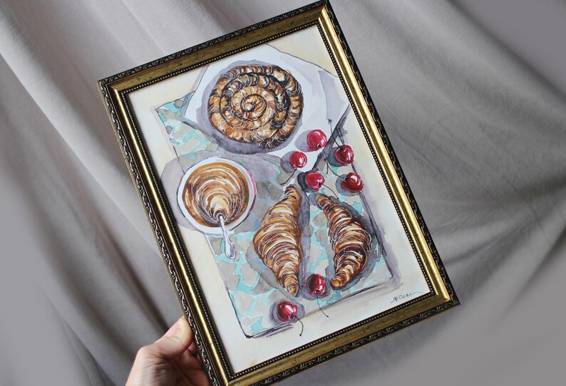 May include: Watercolor painting of a breakfast scene with a croissant, a pastry, a cup of coffee, and cherries on a blue and white patterned tablecloth.