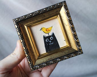 ミニサイズの黒猫の油絵、頭に鳥が乗っている、額装済みオリジナル