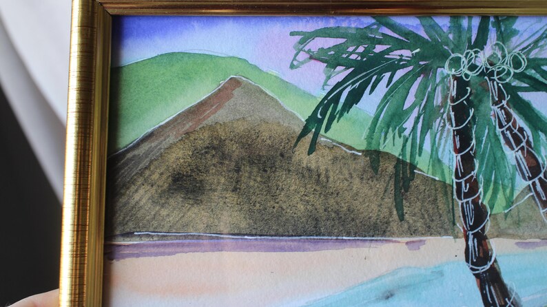 May include: A watercolor painting of a tropical scene with a palm tree in the foreground and a mountain in the background. The sky is a light blue with purple and pink hues. The palm tree has green leaves and a brown trunk. The mountain is a dark brown with a green top.