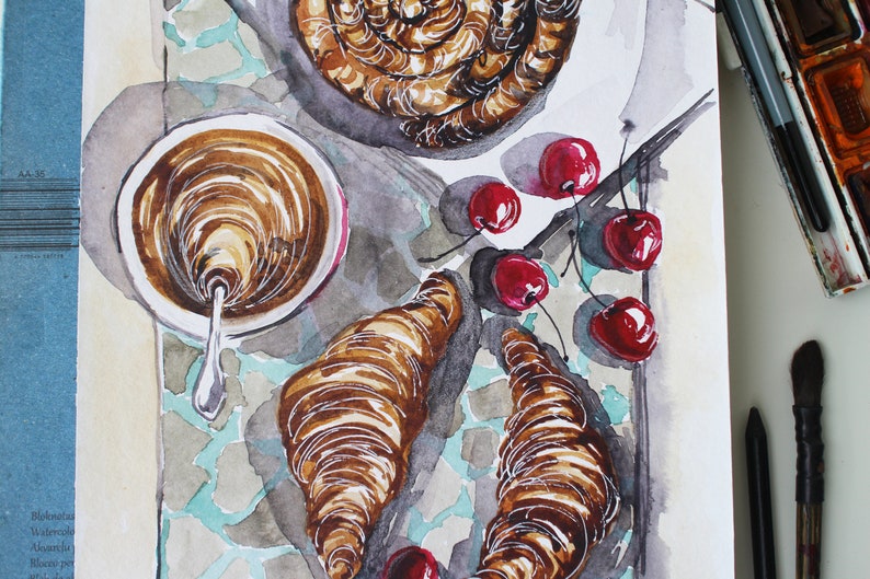 May include: A watercolor painting of a breakfast scene with a cup of coffee, two croissants, and a swirl of pastry. There are also red cherries scattered around the food.