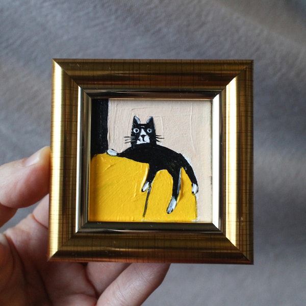 Mini gato negro comparte una silla amarilla. Pintura al óleo: Obra de arte original hecha a mano y enmarcada (2 x 2 pulgadas).