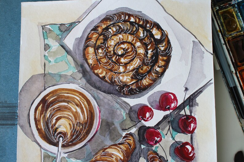 May include: Watercolor painting of a breakfast scene with a pastry, a cup of coffee, and cherries. The pastry is a swirl of brown and white, and the coffee is a dark brown. The cherries are red and have green stems.