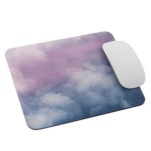 Puede incluir: Una alfombrilla de ratón de acuarela azul y púrpura con un diseño de nubes. La alfombrilla de ratón está hecha de un material suave y duradero y es perfecta para proteger tu escritorio de los arañazos.
