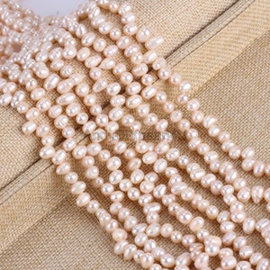 May include: A close-up shot of several strands of light pink freshwater pearls. The pearls are oval and have a natural sheen. The strands are displayed on a neutral fabric, emphasising the pearls' colour and texture. The image is well-lit, highlighting the details of the pearls.