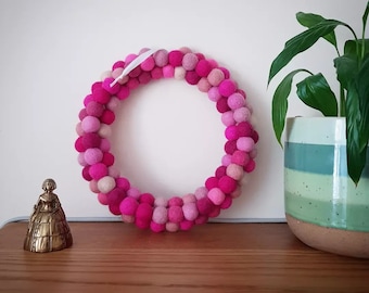 Felt Ball Wreath in Shades of Pink made with a Repurposed Embroidery Hoop.