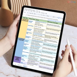 May include: A digital tablet displaying a detailed spreadsheet titled "Teacher Command Center." The screen shows organized lesson plans, curriculum, and classroom operations. A stylus rests on the screen, and the tablet is held by a person.