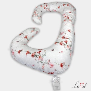 May include: A white pregnancy pillow with a floral pattern in shades of pink and red. The pillow is shaped like a large letter J and is designed to provide support for pregnant women.