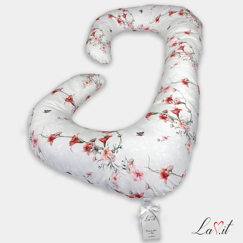 May include: A white pregnancy pillow with a floral pattern in shades of pink and red. The pillow is shaped like a large letter J and is designed to provide support for pregnant women.