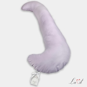 Pode incluir: Uma almofada de corpo em forma de J, de cor lavanda claro, com uma capa de tecido liso. Uma pequena etiqueta retangular branca est&aacute; presa &agrave; curva inferior com uma fita branca, apresentando o texto La.it e outros pequenos detalhes impressos.