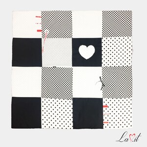 May include: Black and white baby play mat with different patterns, including polka dots, checkered, and a heart shape.