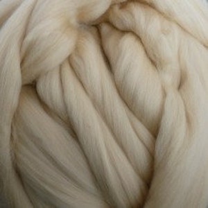 May include: A close-up of a large bundle of white wool roving. The wool is soft and fluffy, and it is perfect for spinning or felting.