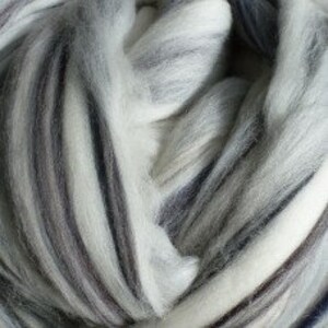 May include: White, gray, and black wool roving. The roving is arranged in a swirl pattern.